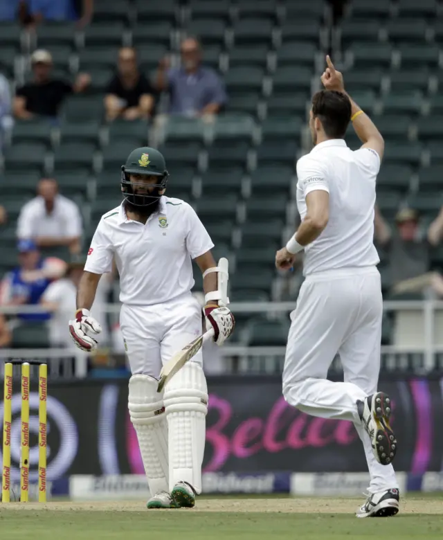 Hashim Amla walks off after being caught off the bowling of Steven Finn