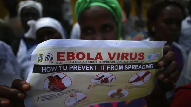 A woman holding a poster about Ebola in Liberia