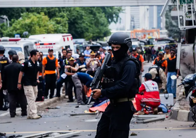 An Indonesian policeman stands guard in front of a blast site at the Indonesia capital Jakarta on 14 January 2016 in Jakarta, Indonesia