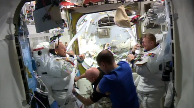 Spacewalkers and crew inside the space station