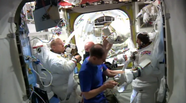 Spacewalkers and crew inside the space station