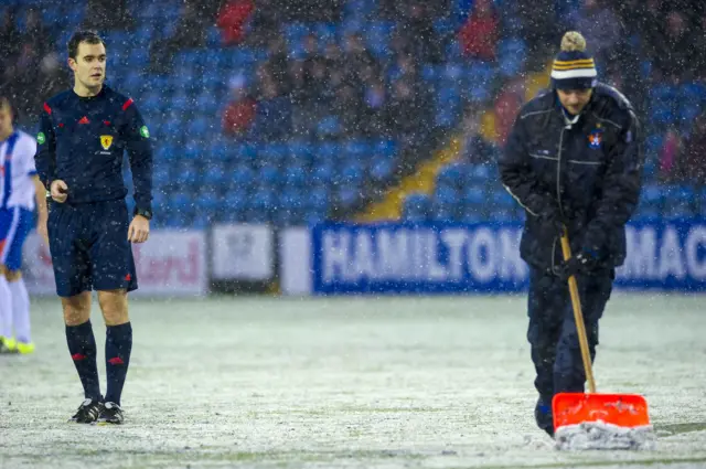 The Rugby Park groundsman works to clear the pitch