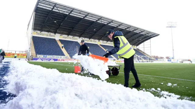 Snow is cleared from the pitch at the Falkirk Stadium