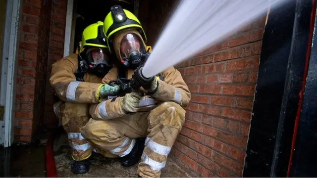 Firemen using a hose