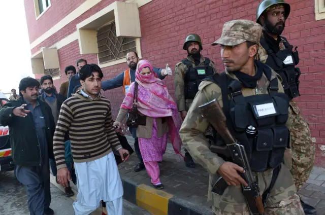 Pakistani army soldiers rescue people from Bacha Khan university following an attack by militants in Charsadda