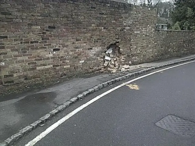 bricks crumbling from a hole in the wall