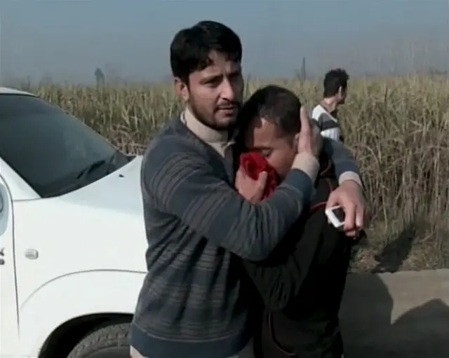 People react outside Bacha Khan University where an attack by militants took place, in Charsadda