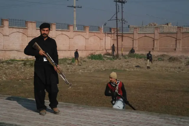 This photograph taken from a mobile phone shows Pakistani security personnel taking position outside the Bacha Khan university following an attack by gunmen in Charsadda, about 50 kilometres from Peshawar, on 20 January 2016