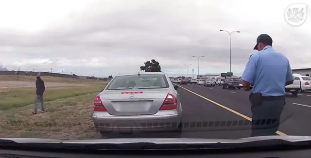 South African police officer approaching a car