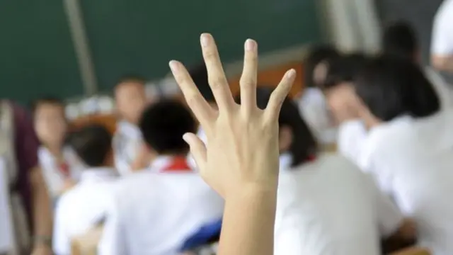 A hand being raised in a classroom