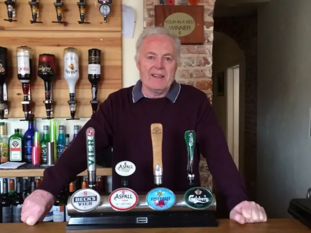 Dennis Gilligan behind the bar of the White Lady in Worstead