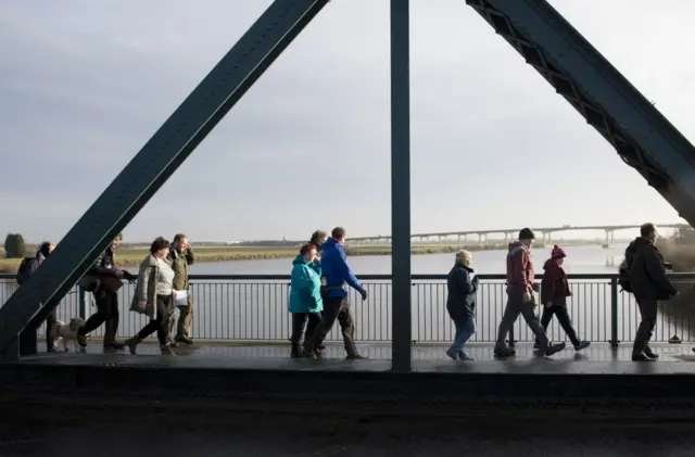 Jo walks over a bridge