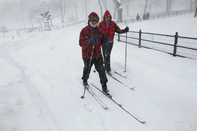 A couple go cross country skiing in Central Park.