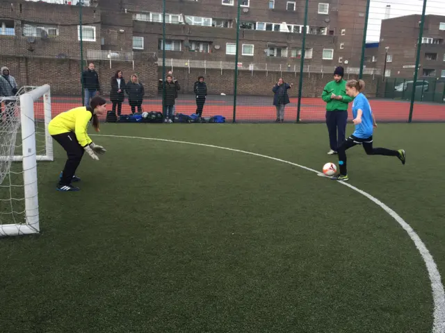 girl about to kick football into the goal