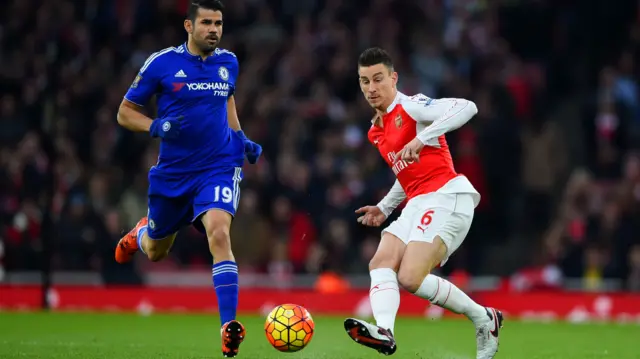 Laurent Koscielny of Arsenal passes the ball under pressure from Diego Costa