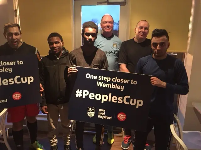 Group of men holding up a People's Cup banner