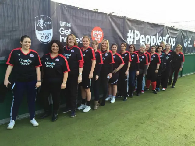 Line of female football players against People's Cup banner