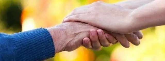 Carer holding man's hand