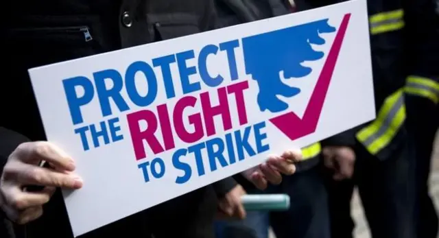 Protester holding a 'Protect The Right To Strike' sign