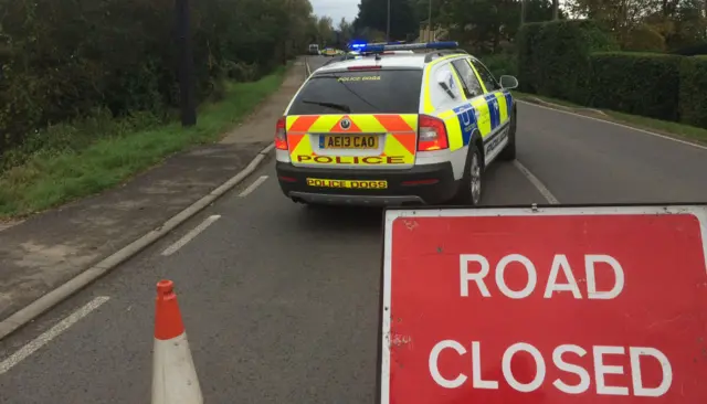 Police car beside road closed sign.