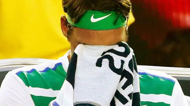 Roger Federer wipes his face