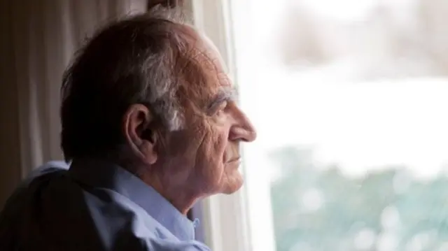 Old man looking out of window