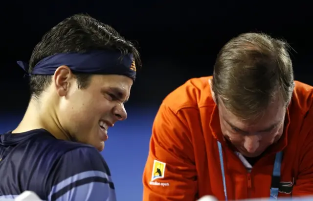 Milos Raonic of Canada reacts as he receives treatment