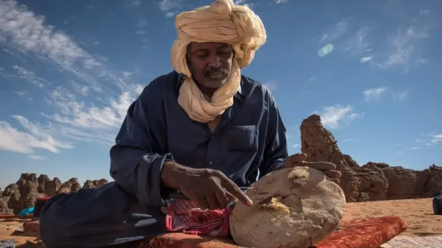 A Touareg tribesman cuts bread in the Meggedat valley, north west of Libya"s Akakas mountain region, in the desert of the western Ghat District, in photo released on 25 January 2016