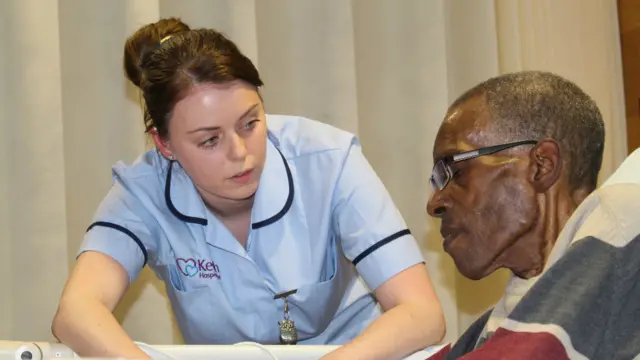 Nurse Lisa Jarman at the bedside of Tony Jules