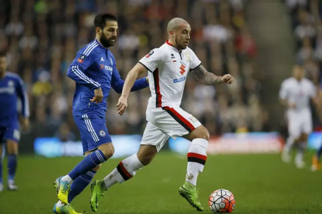 Milton Keynes Dons’ Samir Carruthers, right, competes for the ball with Chelsea"s Cesc Fabregas during the English FA Cup fourth round soccer match between Milton Keynes Dons and Chelsea at Stadium mk