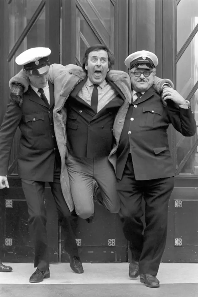 Sir Terry Wogan with security guards