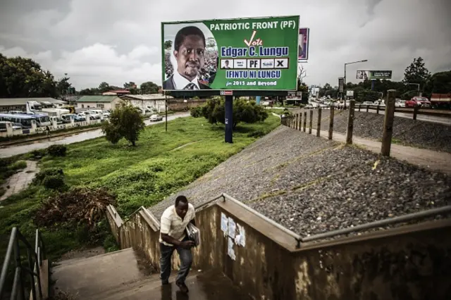 A Zambian walks on January 19, 2015 past a giant billboard, featuring the presidential candidate of the Zambian ruling party Patriotic Front, Edgar Lungu, on the eve of the Zambian presidential elections in Lusaka.