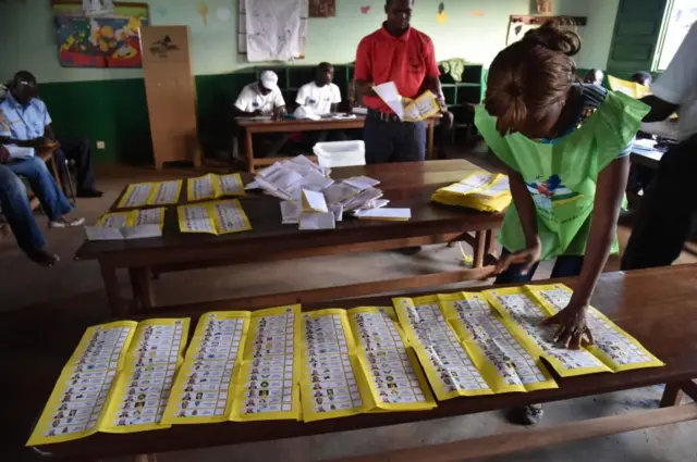 Election workers count votes after polls closed during the presidential and legislatives elections in Bangui"s city center on 30 December 2015