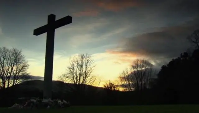 Cross surrounded by flowers to pay tribute to the babies involved in the ashes scandal