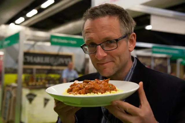Michael Mosley holding up a meal on a plate
