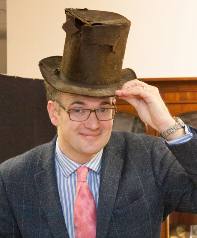 Charles Hanson with the 200-year-old hat found found wedged up a fireplace at a Georgian farmhouse in Derbyshire