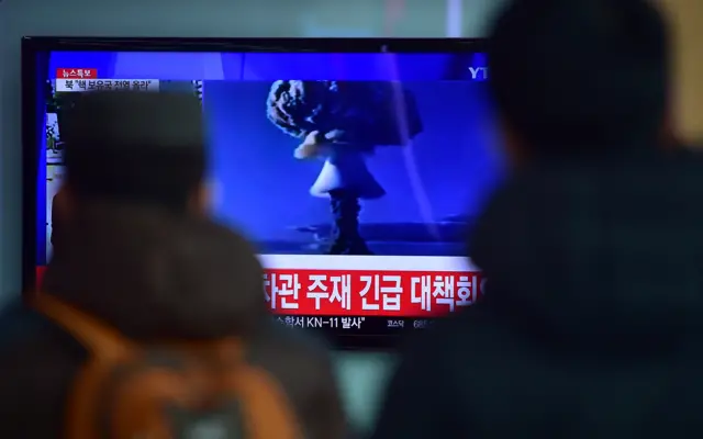 People watch a news report on North Korea's alleged first hydrogen bomb test at a railroad station in Seoul on 6 January 2016