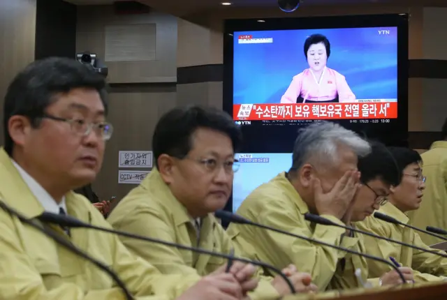 South Korean Foreign Ministry officials attend an emergency meeting as a TV news program showing North Korea"s announcement at the ministry in Seoul, South Korea, Wednesday, 6 January 2016.