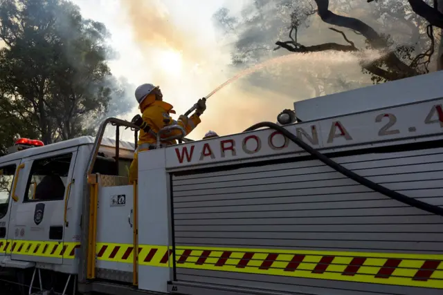 handout photo taken on January 7, 2016 and released on January 8 by the Department of Fire and Emergency Services shows firefighters battling a fire near Waroona in Western Australia