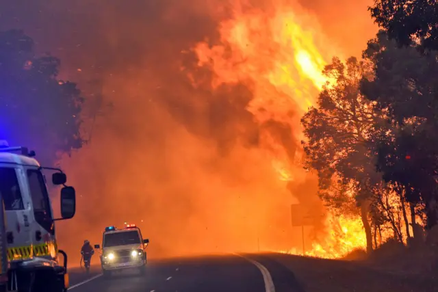 handout photo taken on January 7, 2016 and released on January 8 by the Department of Fire and Emergency Services shows firefighters battling a fire near Yarloop in Western Australia.