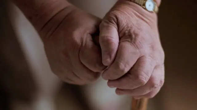 Pensioner holding walking stick