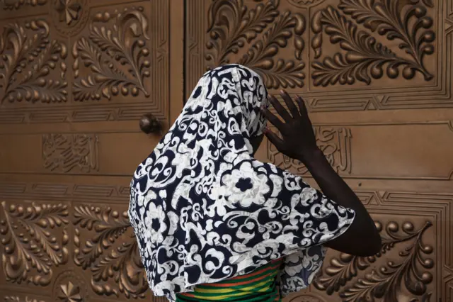 A Muslim woman is praying at the entrance of the Central Mosque in Lagos on July 5, 2016