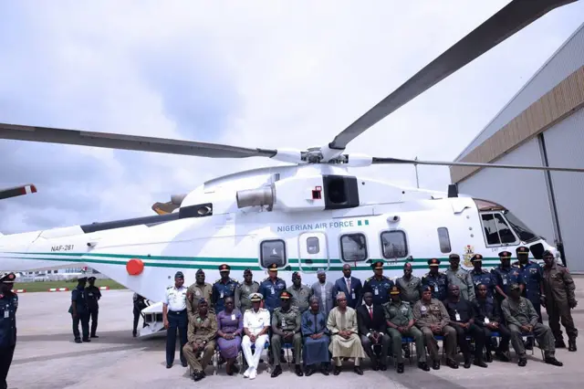 Group shot in front of helicopter