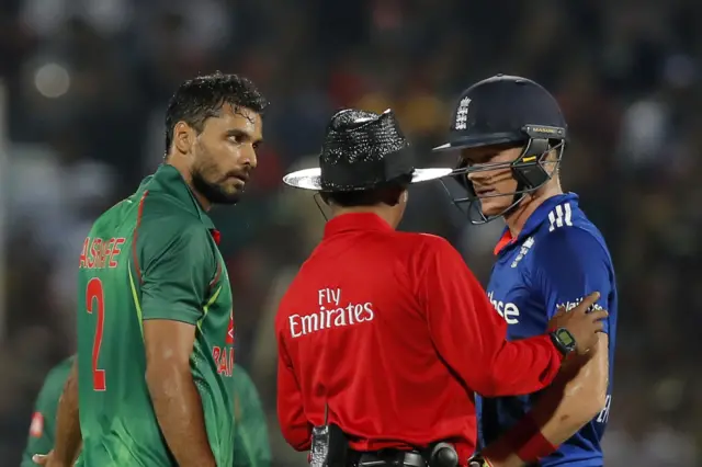 The umpire talks to Sam Billings