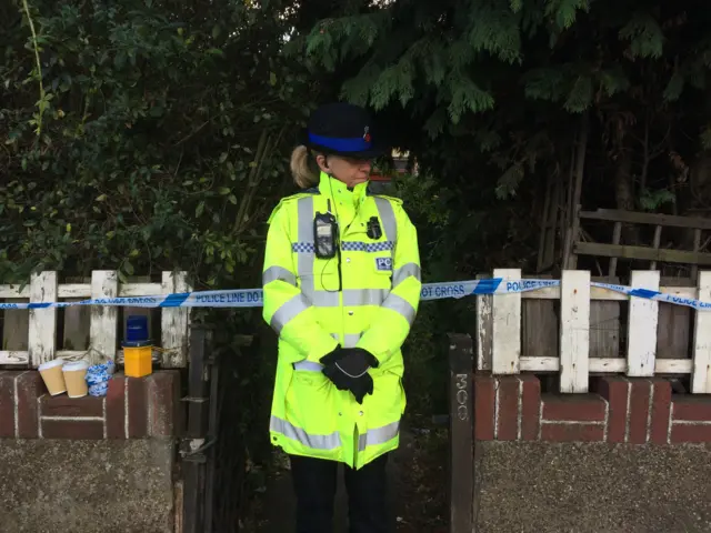 Police officer outside bungalow