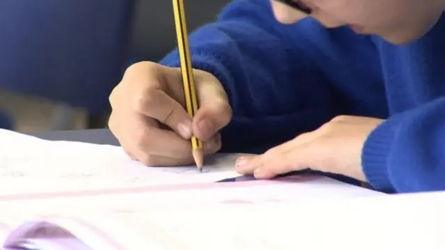 A boy takes a test in school