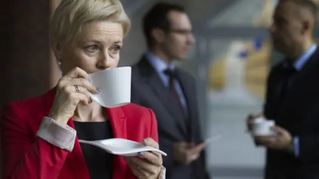 Older woman drinks from mug