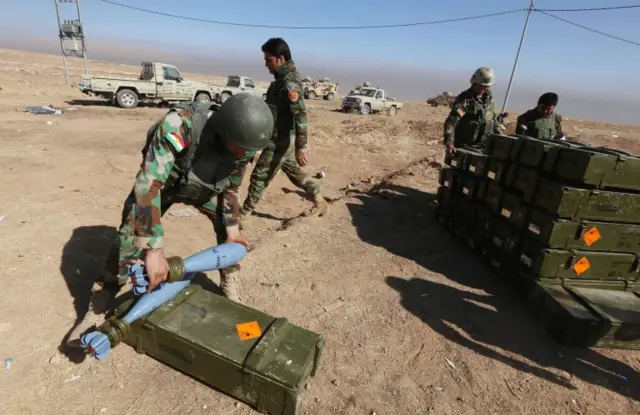 Iraqi Kurdish Peshmerga fighters arrange boxes with mortar shells on the top of Mount Zardak, about 25km (15 mles) east of Mosul