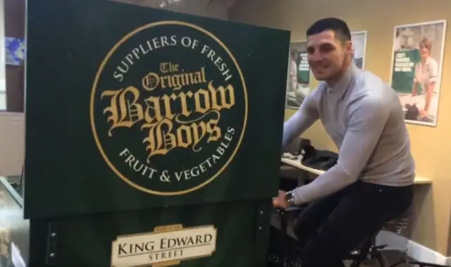 Boxer Tommy Coyle on an old fashioned cycle with a greengrocers barrow on the front