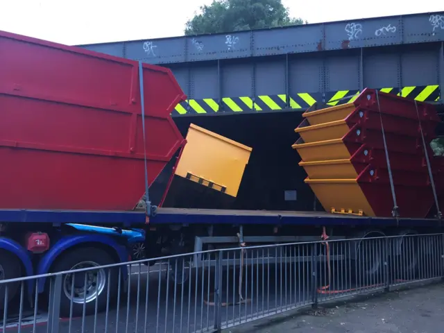 Skips stuck under bridge in Hertford